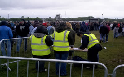 A low-resolution outdoor gate line with anonymous stewards.
